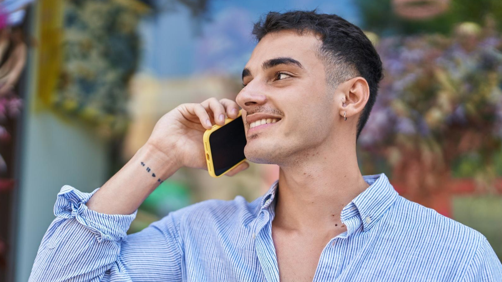 Smiling man outdoors on a phone call, showcasing the effectiveness of mobile cloud phones in Knoxville that support flexibility and connectivity.