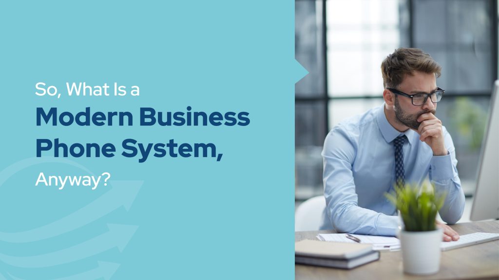 Professional man working at a computer with text asking “What Is a Modern Business Phone System?” illustrating the Benefits of business phone systems in today’s workplace.